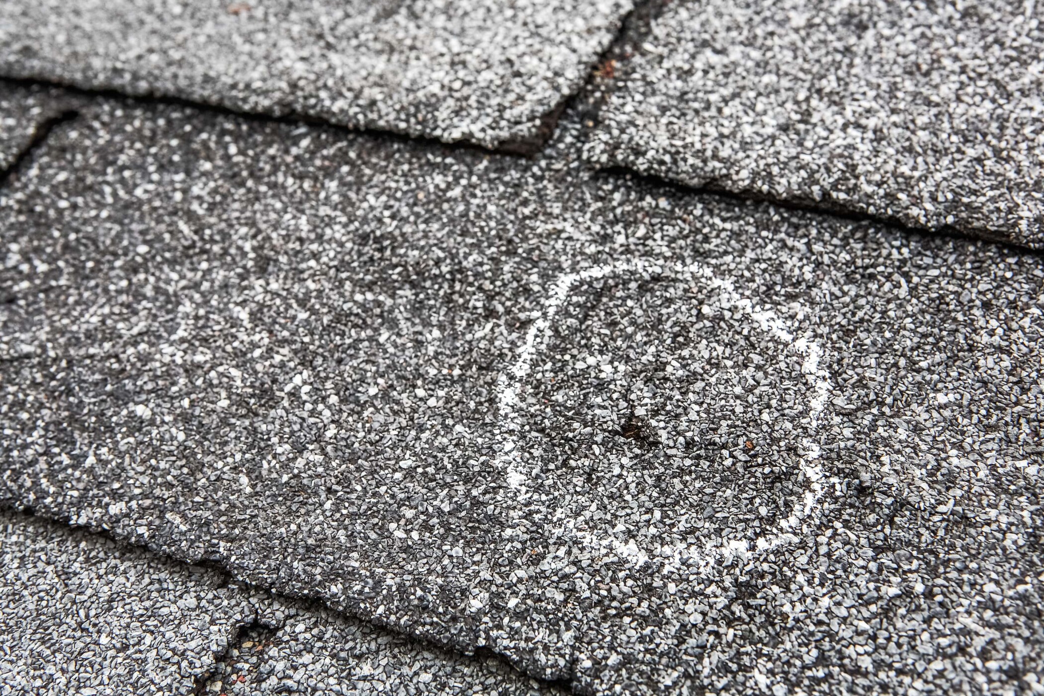 hail damaged shingles with chalk circle