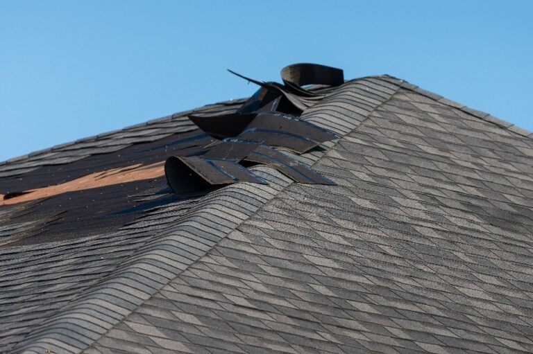 damaged asphalt shingle roof by wind