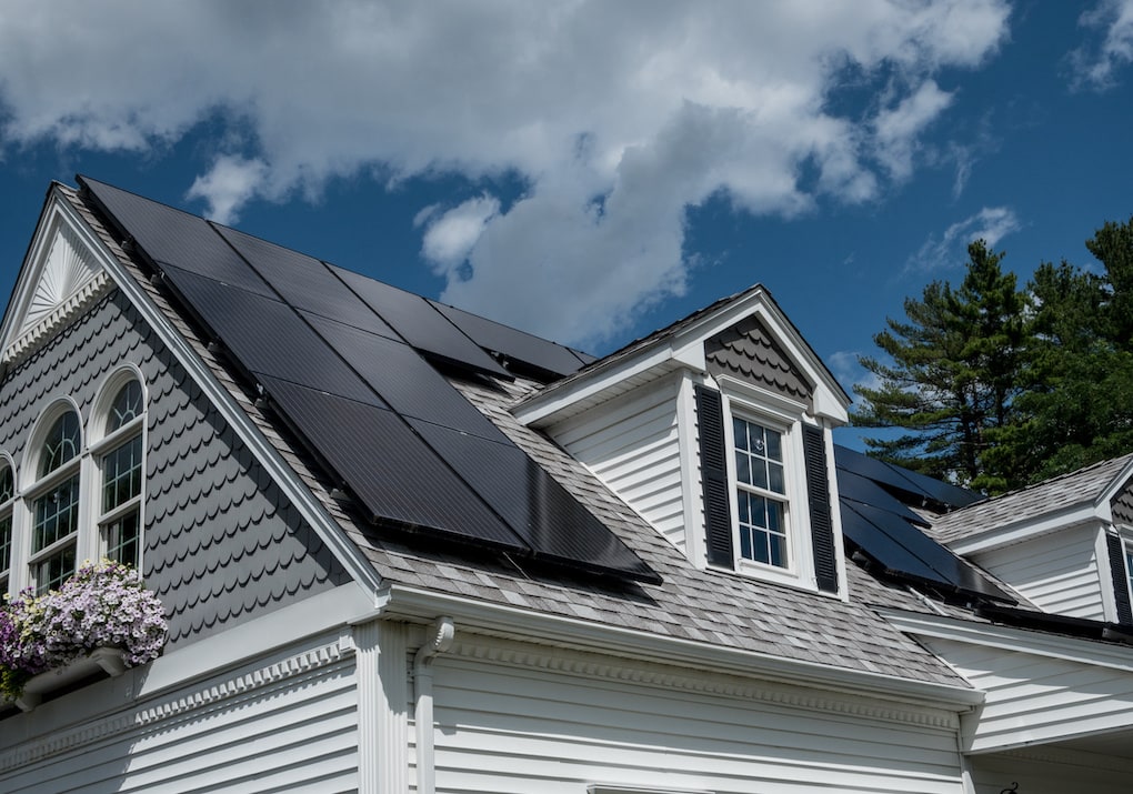 black solar panels on gray shingle roof