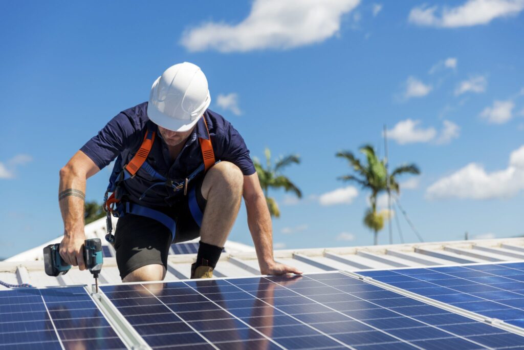 worker with white hard hat installing solar roof