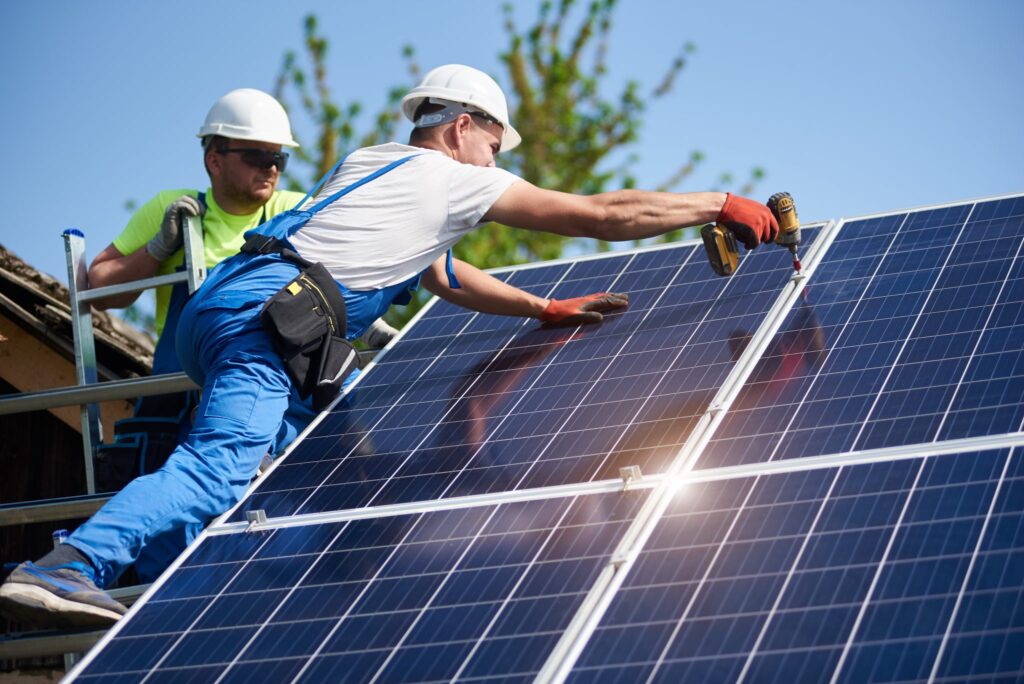 florida roof workers using a drill to install solar panels